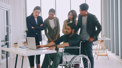 a disabled company employee is explaining a computer program to a group of colleagues.
