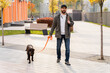 © NFstock - So cozy with you. Full length view of the calm man walking with his dog while spending time at the autumn street. Pets and people concept