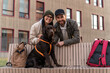 © NFstock - Young couple in love enjoying with their adorable Labrador dog while walking at the street and posing to the camera. Pet sitting at the bench