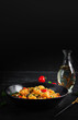 Classic italian pasta fusilli marinara with mussels, green olives and capers on dark table.  Fusilli pasta with sauce marinara