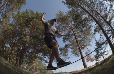 Man balancing on a slackline in a picturesque park