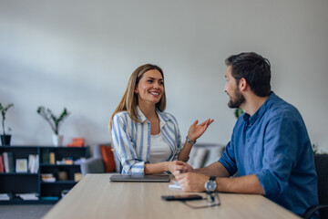 Two ambitious people talking to each other at the office.