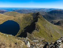 Striding Edge And Red Tarn. View From Helvellyn In Lake District, UK On A Beautiful Day With Clear Blue Sky. Majestic Mountain Landscape Scenery.