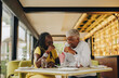 © Jacob Lund - Romantic senior couple sharing a delicious milkshake in a cafe
