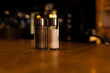 Salt and pepper shakers standing on a wooden table in a dark bar