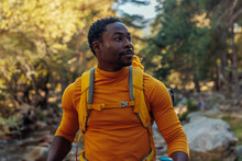 African American hiker hiking up river