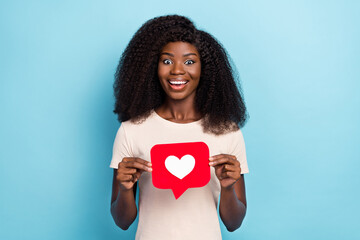 Sticker - Photo of cheerful pretty girl beaming smile hands hold paper like card isolated on blue color background