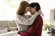 © Wavebreak Media - Side view of loving caucasian lesbian couple with eyes closed embracing and romancing in kitchen