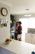 © Wavebreak Media - Romantic caucasian mid adult lesbian couple looking at each other and dancing in kitchen, copy space