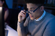 © Wavebreak Media - Asian businessman holding eyeglasses while looking at computer screen while working in office