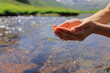 © Antonioguillem - Cupped woman hands catching water in a river