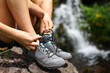 © Antonioguillem - Hiker tying shoe laces in the mountain