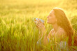 © Antonioguillem - Happy woman drinking coffee in a field at sunset