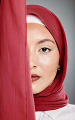 Wall Mural - Closeup portrait of elegant muslim woman wearing a hijab, posing in studio. Half headshot of stunning confident arab model isolated against grey background. Zoomed in on fashionable middle eastern