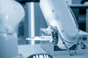 The automatic  robotic arm gripping the metal parts from CNC lathe machine.