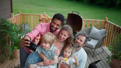 Wall Mural - Family with kids having fun at barbecue party dinner on patio, people sitting and taking selfie.