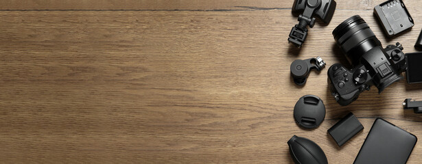 Wall Mural - flat lay composition with camera and video production equipment on wooden background, space for text