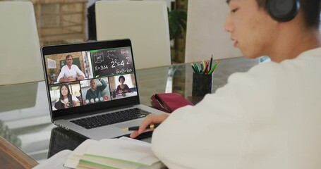 Wall Mural - Asian teenage boy using laptop for video call, with male teacher and class on screen