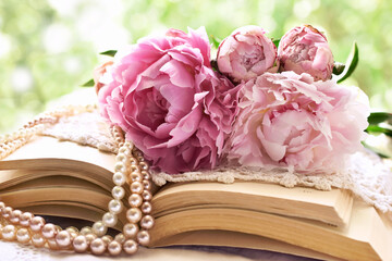 Poster - Romantic still life with pink peonies lying on old books in the garden