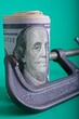 'Clamp squeezing roll of U.S. 100 dollar bills'