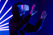 © Seventyfour - Futuristic shot of young woman wearing VR headset in 3 dimensions with neon light beams , copy space