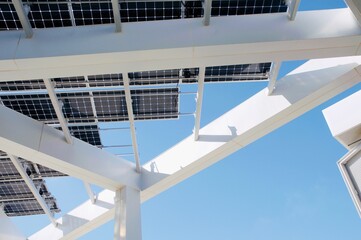  Architectural view of white beams and solar panels against blue sky