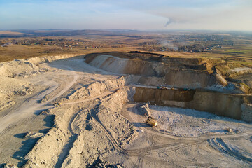 Wall Mural - Aerial view of open pit mining site of limestone materials for construction industry with excavators and dump trucks