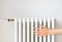 Man Checking Radiator Of The Central Heating System