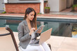 © Hugo - serious businesswoman using her tablet in a hotel courtyard