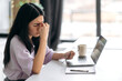 © Kateryna - Deadline, overworked concept. Exhausted Asian girl, sitting at home at a laptop, massages the bridge of her nose, tired of online work or study, has not rested for a long time, needs a break