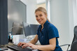 © Yaroslav Astakhov - Nurse on Duty working on computer at the Reception Desk in modern clinic. High quality photo