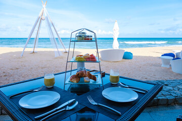 Wall Mural - Breakfast on the beach in Phuket Thailand, a Luxury breakfast table with food and beautiful tropical sea view background., luxury travel and lifestyle. 