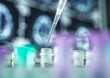 © Connect Images - Close-up of pipette and test tubs in front of brain scans