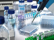 © Connect Images - Scientist pipetting samples from clinical trail into multi well