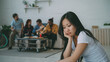 © silverkblack - Young asian girl feels upset and isolated while her flatmates celebrating party at home