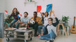 © silverkblack - Multi-ethnic group of friends sports fans with French flags watching football championship on TV together at home indoors and cheering up favourite team