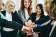 Multiracial business people celebrating together stacking hands inside modern office - Focus on top hands