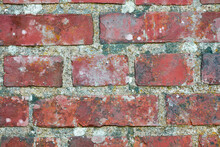 Closeup Of A Dirty Red Brick Wall With Copy Space. Old Deteriorating Exterior Surface Of A House. Detail And Rough Texture Of Cement Blocks Concrete Layers For Construction Of A Solid Structure
