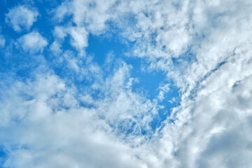 White clouds on a blue sky background.