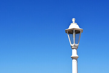 Vintage white street ligh,  against a deep blue sky. No people. Copy space.