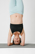 © face_reader_img - Yoga woman doing handstanding indoor.Healthy body and mind. Vertical.