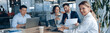 © Yaroslav Astakhov - confident smiling businesswoman sitting at the office with group of colleagues, on background.