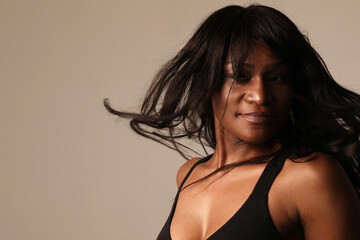 Beautiful African American woman with long hair posing indoor. Mock-up.