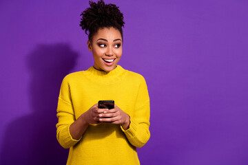 Sticker - Photo of cheerful lady look interested empty space hold telephone blogging isolated on violet color background