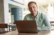 © fotofabrika - Young businessman sitting in cafe working with laptop computer