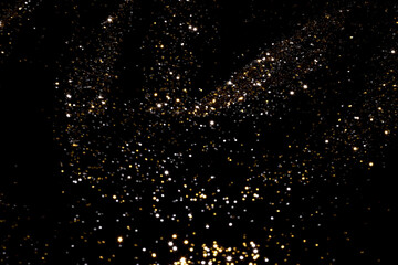 Wall Mural - golden and silver blurred bokeh lights on black background. glitter sparkle stars for celebrate. ove