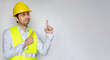 © anut21ng Stock - Asian man in construction clothes looking and pointing hands aside to empty copy space