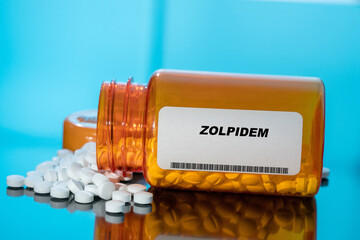 Canvas Print - Zolpidem white medical pills and tablets spilling out of a drug bottle. Macro top down view with copy space.