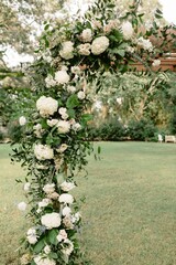 Wall Mural - Selective focus shot of the wedding venue arch decorated with off white flowers