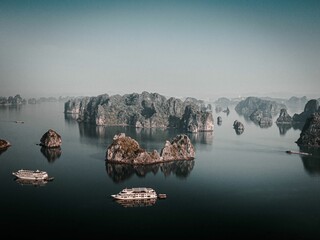 Mesmerizing view of big rocks in the sea with passenger ships in Ha Long bay